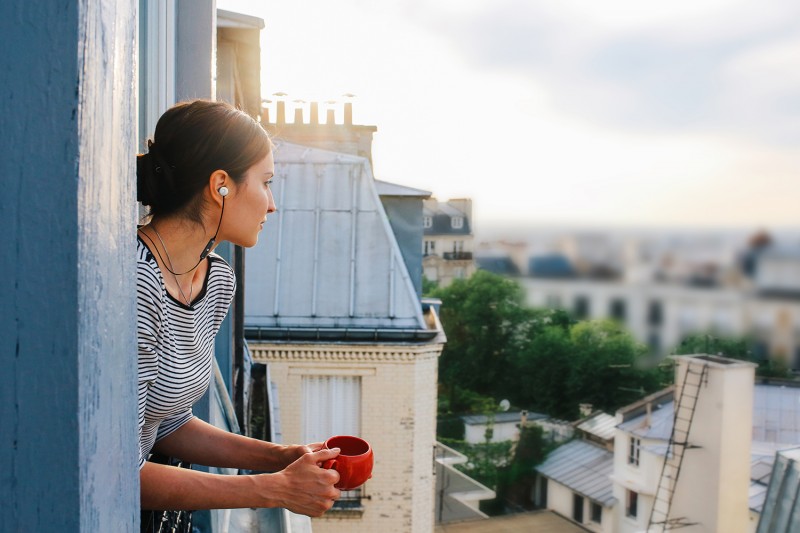 Young woman enjoying the view from a Parisian apartment